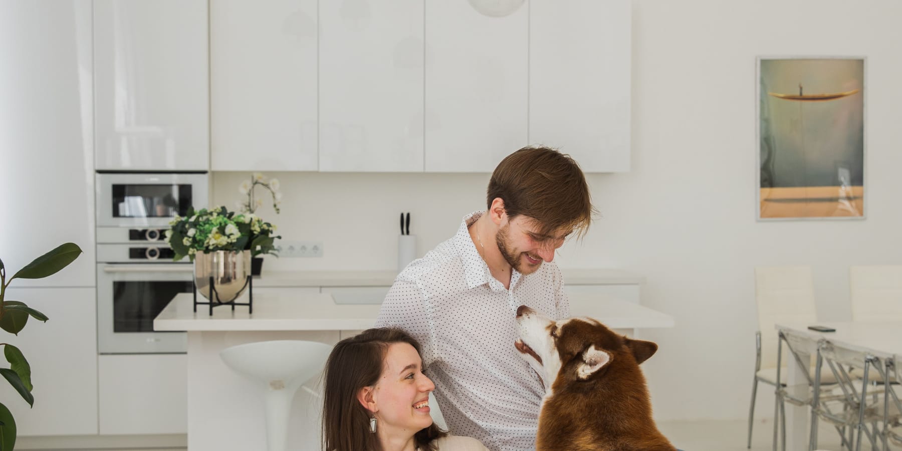 A couple at home in the morning with their husky